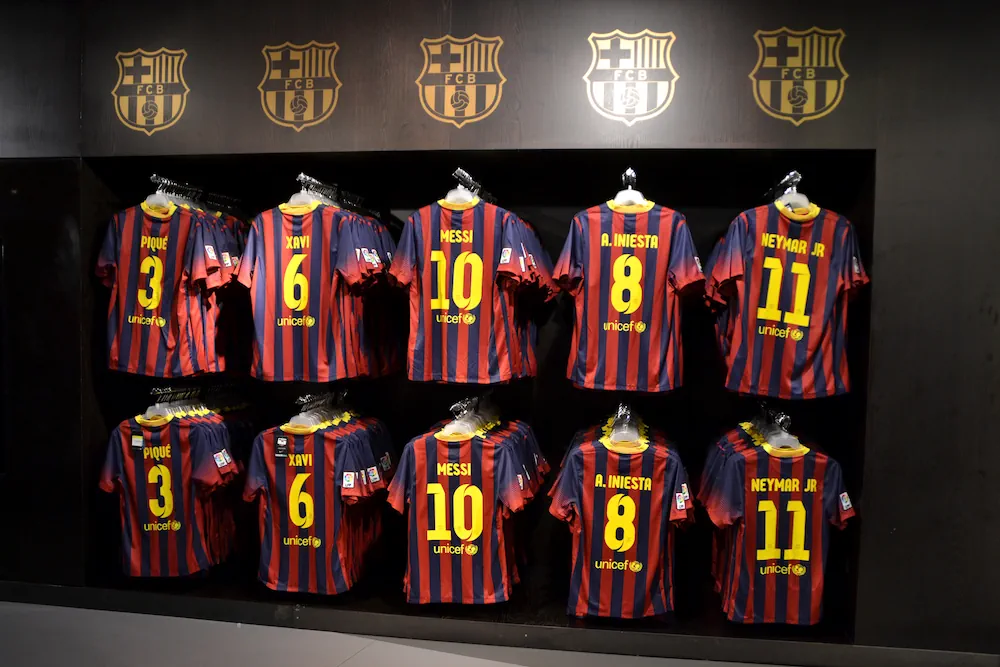 Barcelona-shirts met hun rugnummer erop in een supporterswinkel.