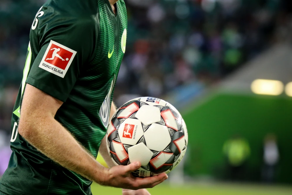 Bundesliga-logo op het shirt van een speler en de voetbal in zijn handen