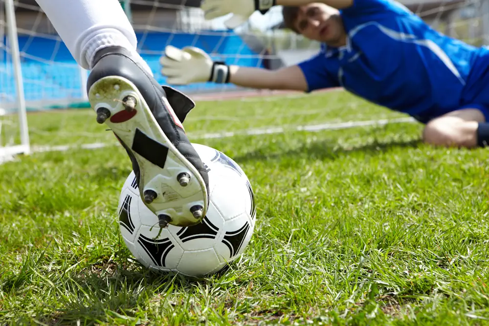 Voetballer van dichtbij die op het punt staat te scoren