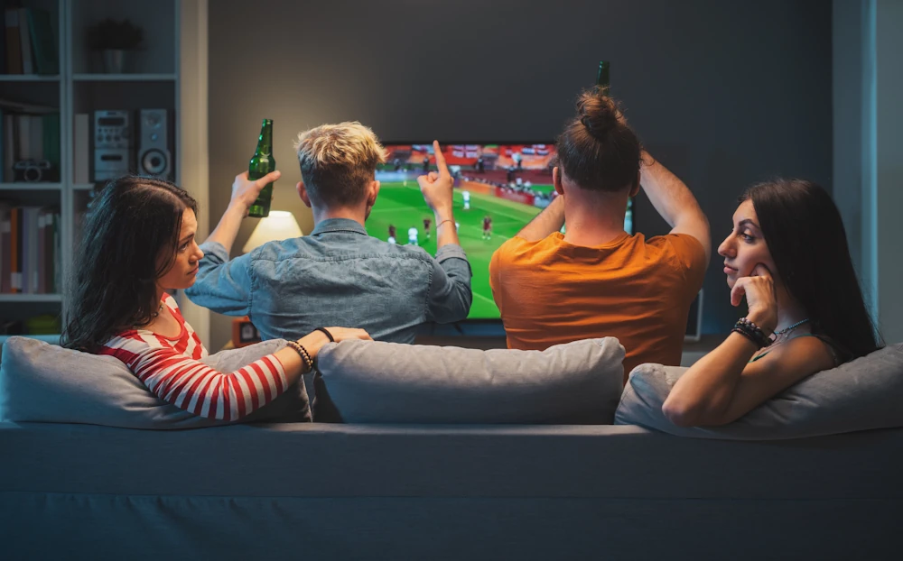 Voetbalfans kijken naar een wedstrijd op tv